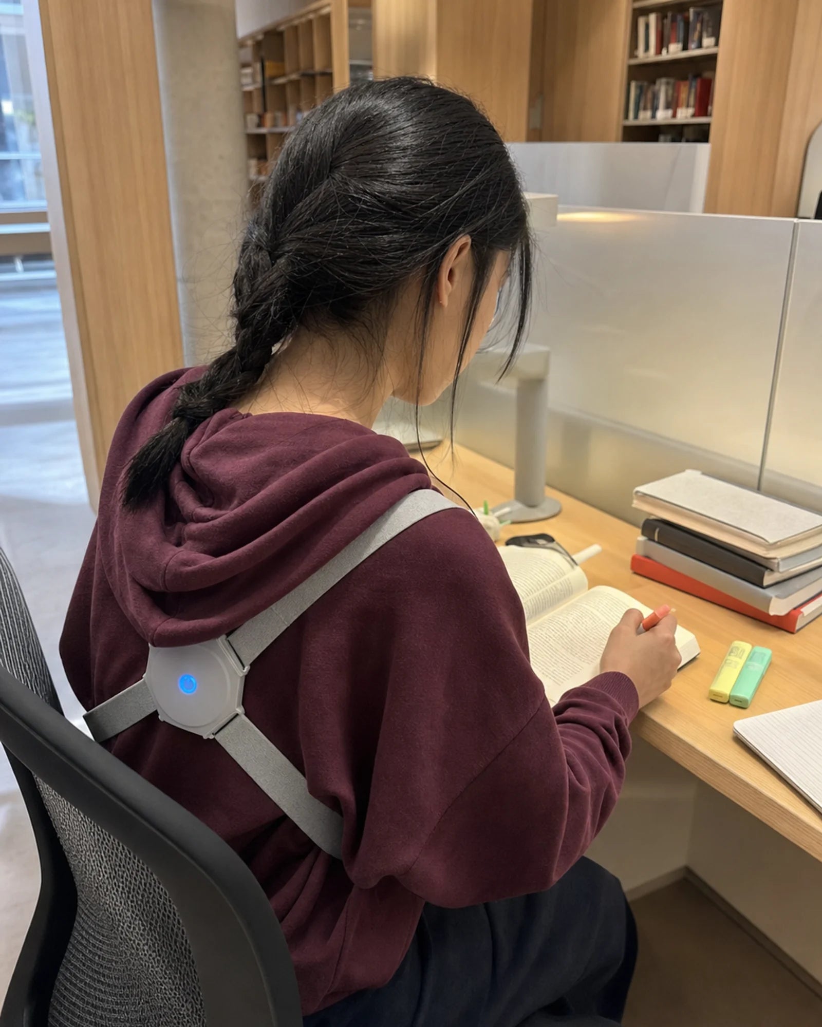 Graduate student studying in a library while wearing AlignNova