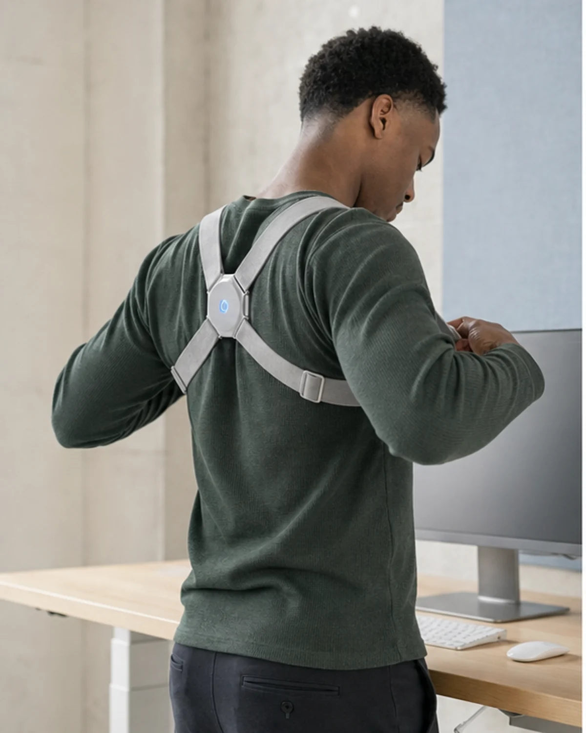 Man putting on AlignNova and adjusting both light-gray straps